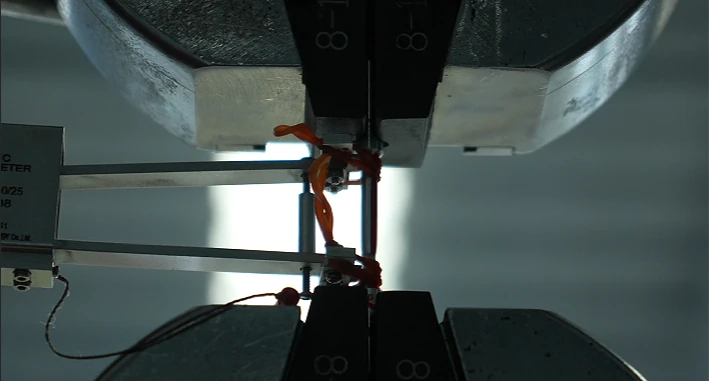 Aluminum alloy specimen between the chucks of LSW factory material tensile testing machine
